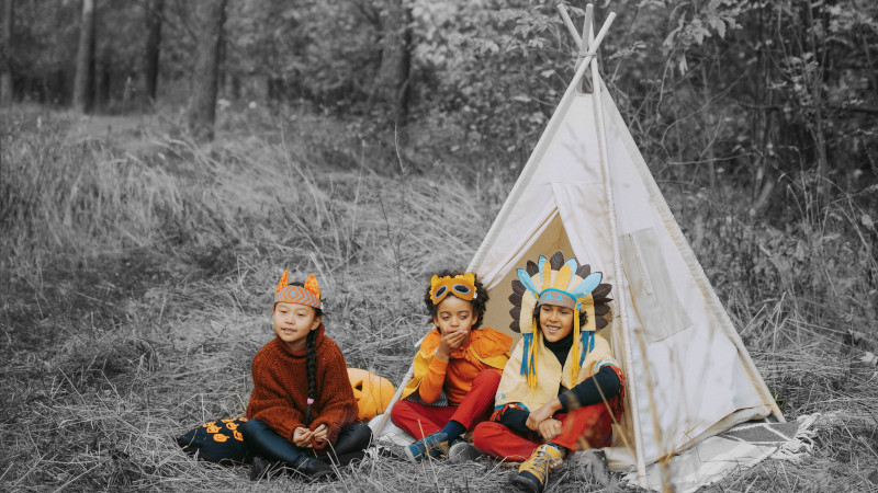 Enfants qui jouent aux indiens dans un tipi